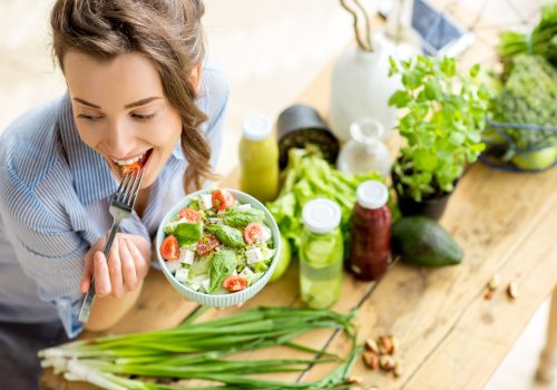 Young,And,Happy,Woman,Eating,Healthy,Salad,Sitting,On,The