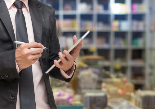 Businessman,Using,The,Tablet,On,Abstract,Blurred,Photo,Of,Book