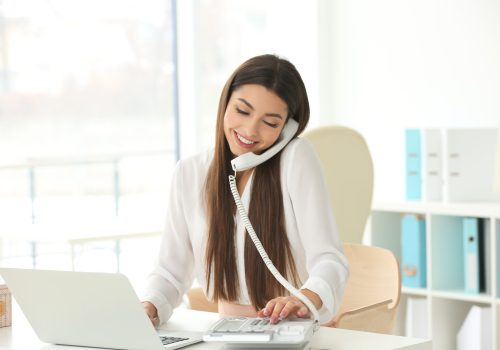 Beautiful,Young,Woman,Talking,By,Telephone,While,Working,With,Laptop